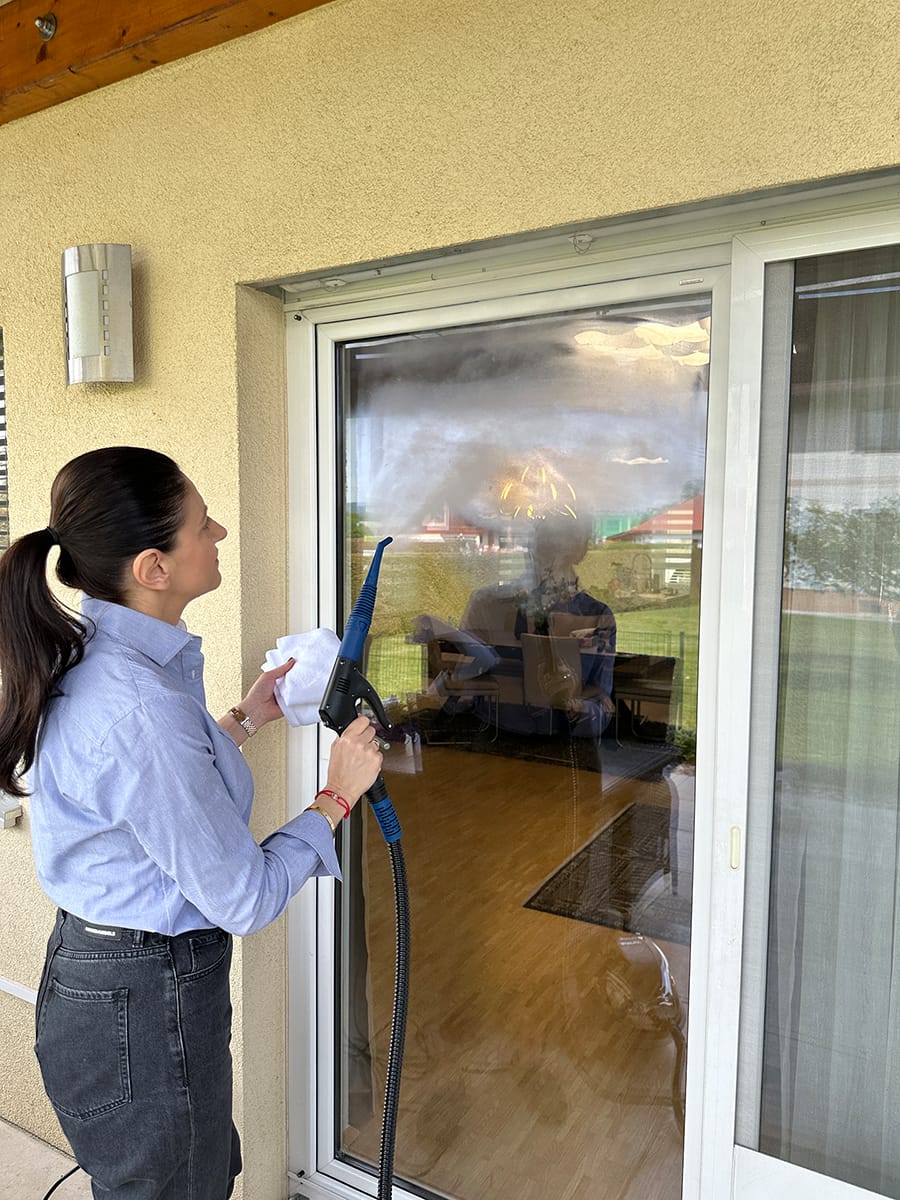 Reinigungskraft bei der Fensterreinigung mit streifenfreiem Ergebnis